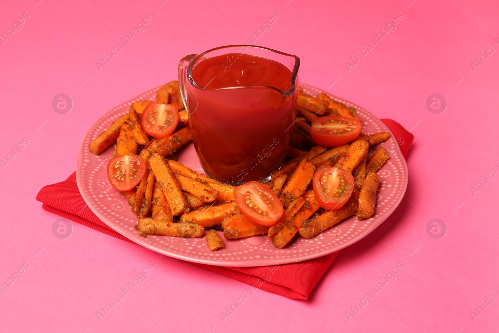 Photo of Tasty ketchup, tomatoes and fried carrots on pink background