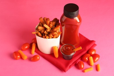 Photo of Tasty ketchup, tomatoes and fried carrots on pink background