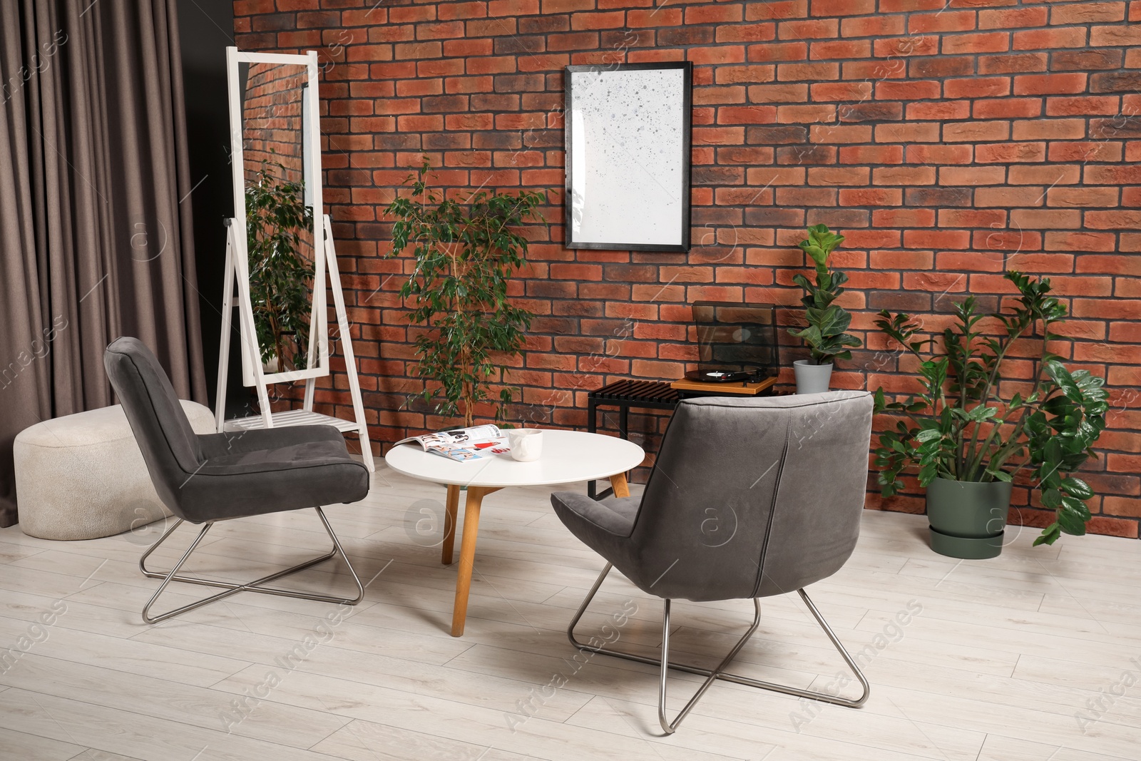 Photo of Soft armchairs, coffee table, mirror and houseplants in cozy living room. Interior design