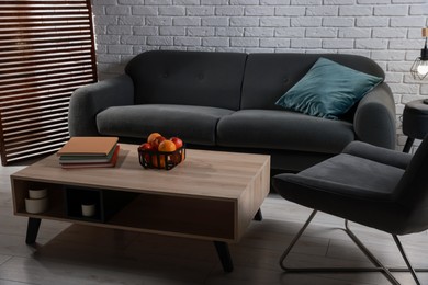 Photo of Comfortable sofa, armchair and coffee table in living room. Interior design