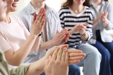 Photo of People applauding during meeting indoors, closeup view