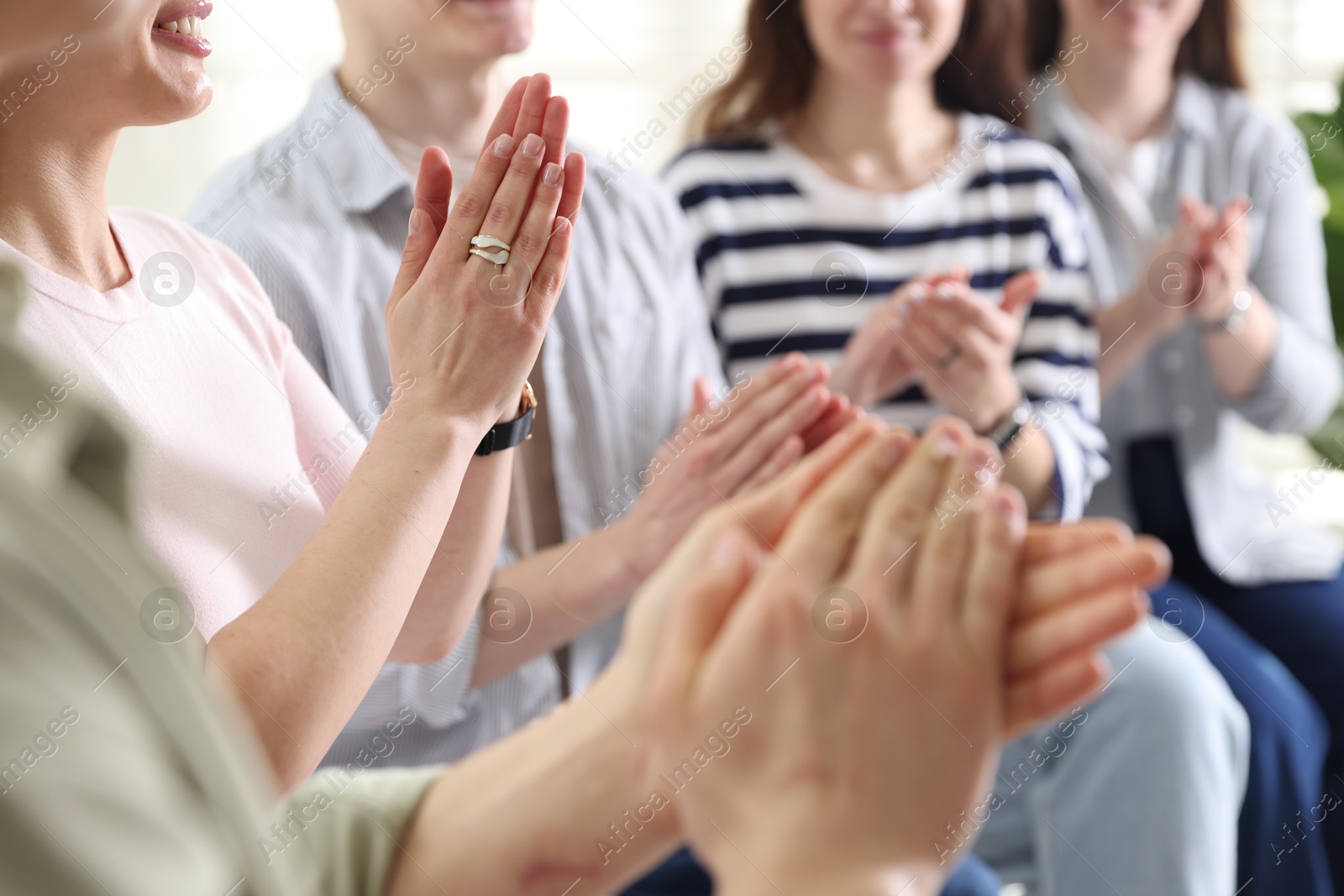 Photo of People applauding during meeting indoors, closeup view