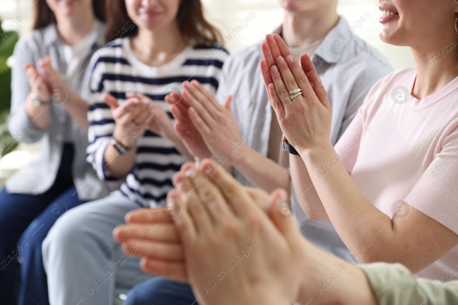 Photo of People applauding during meeting indoors, closeup view