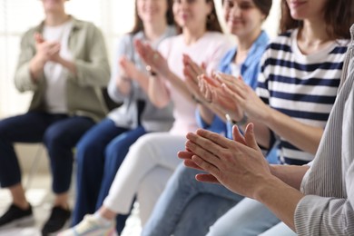 People applauding during meeting indoors, closeup view