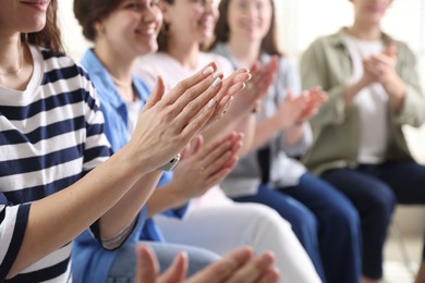 People applauding during meeting indoors, closeup view