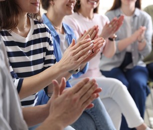 Photo of People applauding during meeting indoors, closeup view