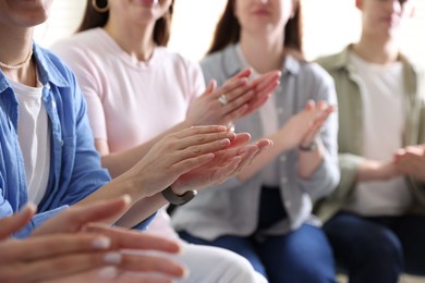 People applauding during meeting indoors, closeup view