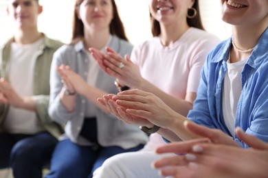 People applauding during meeting indoors, closeup view