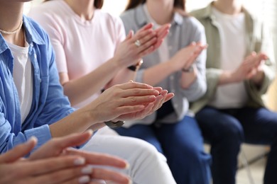 Photo of People applauding during meeting indoors, closeup view