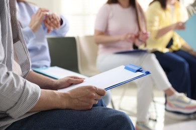 Photo of People with clipboards during meeting indoors, closeup