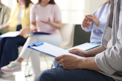 Photo of People with clipboards during meeting indoors, closeup