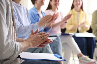 Photo of People applauding during meeting indoors, closeup view