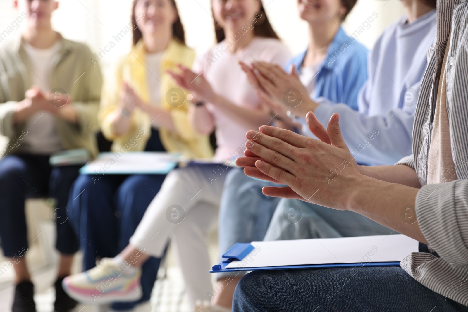 Photo of People applauding during meeting indoors, closeup view