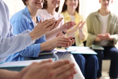 Photo of People applauding during meeting indoors, closeup view