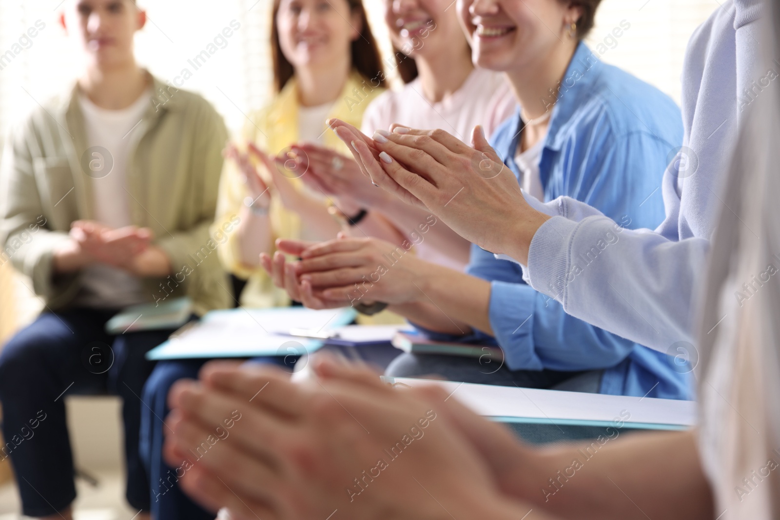 Photo of People applauding during meeting indoors, closeup view