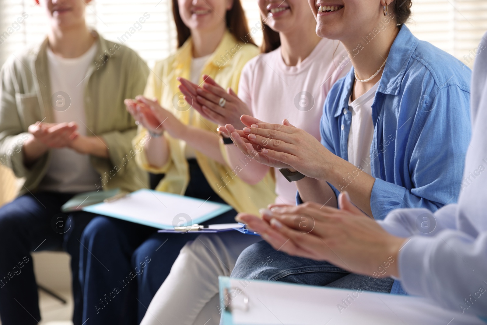 Photo of People applauding during meeting indoors, closeup view