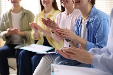 Photo of People applauding during meeting indoors, closeup view