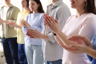 Photo of People applauding during meeting indoors, closeup view