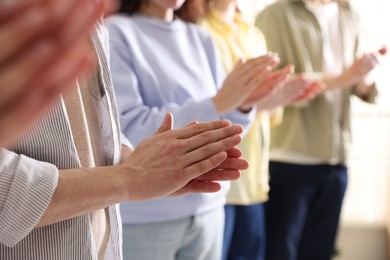 Photo of People applauding during meeting indoors, closeup view