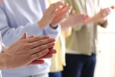 Photo of People applauding during meeting indoors, closeup view