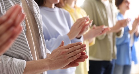 Photo of People applauding during meeting indoors, closeup view