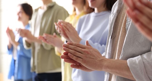 Photo of People applauding during meeting indoors, closeup view