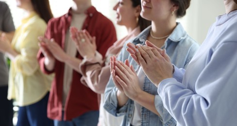 Photo of People applauding during meeting indoors, closeup view