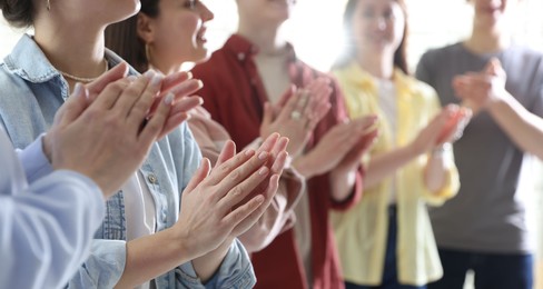 Photo of People applauding during meeting indoors, closeup view