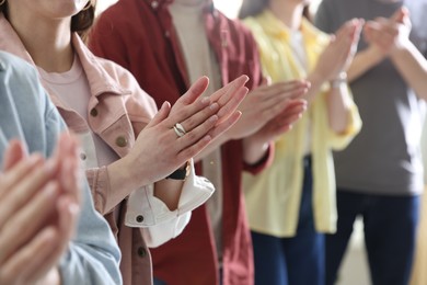 Photo of People applauding during meeting indoors, closeup view