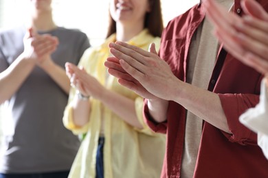 Photo of People applauding during meeting indoors, closeup view