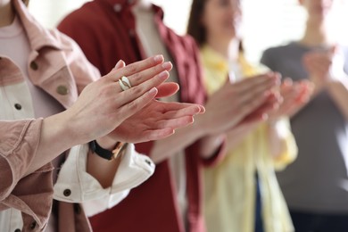 Photo of People applauding during meeting indoors, closeup view