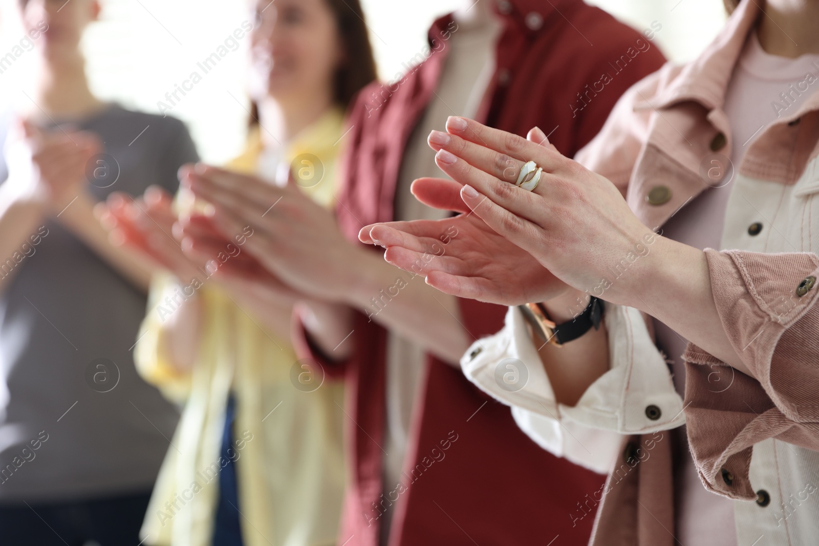 Photo of People applauding during meeting indoors, closeup view