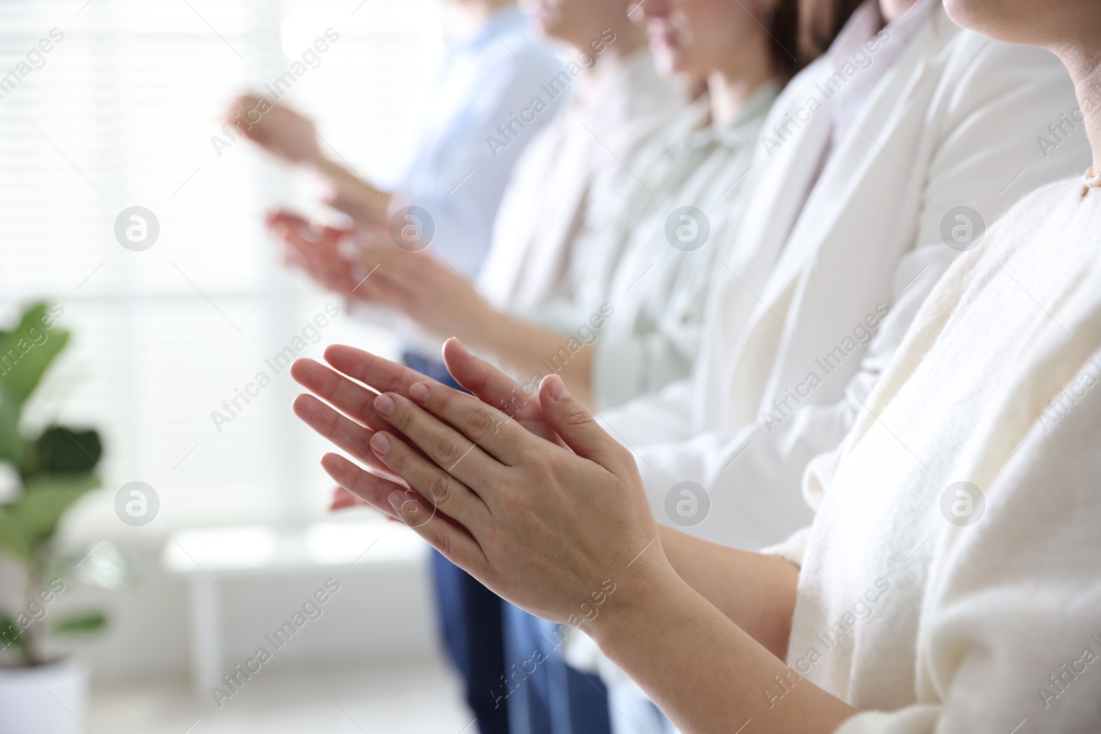 Photo of People applauding during meeting indoors, closeup view