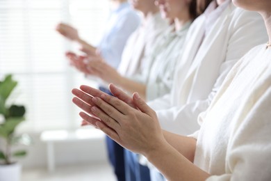 Photo of People applauding during meeting indoors, closeup view