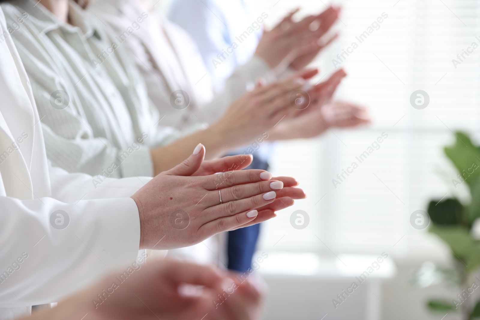 Photo of People applauding during meeting indoors, closeup view