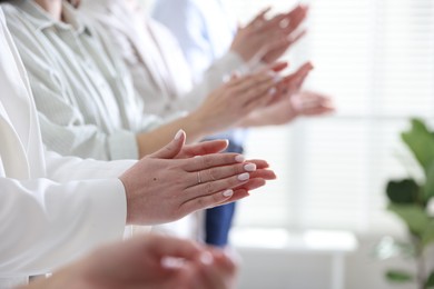 Photo of People applauding during meeting indoors, closeup view