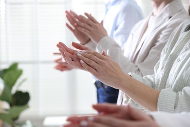 Photo of People applauding during meeting indoors, closeup view