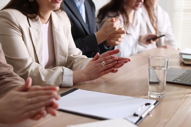 Photo of People applauding at table in office, closeup