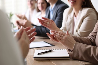 Photo of People applauding at table in office, closeup