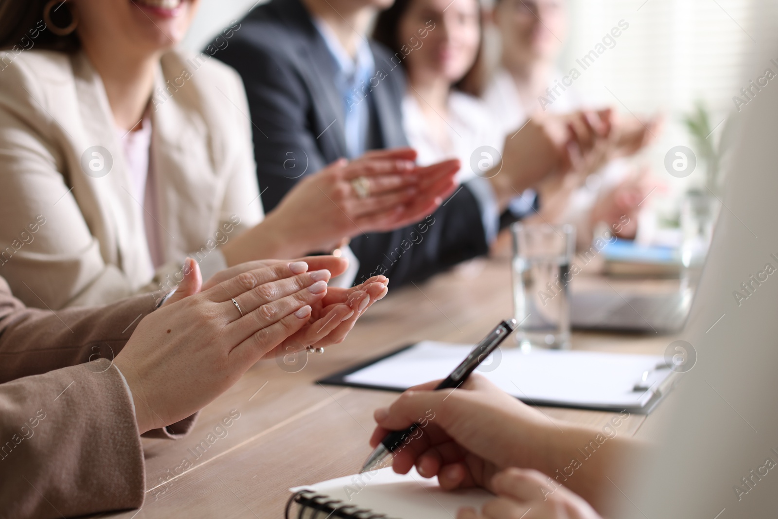 Photo of People applauding at table in office, closeup