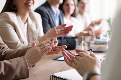 Photo of People applauding at table in office, closeup