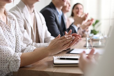 Photo of People applauding at table in office, closeup