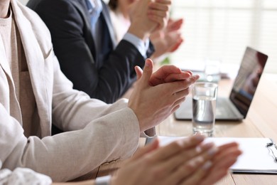 Photo of People applauding at table in office, closeup