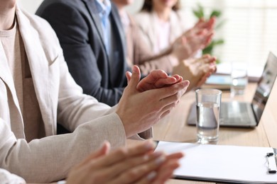 Photo of People applauding at table in office, closeup