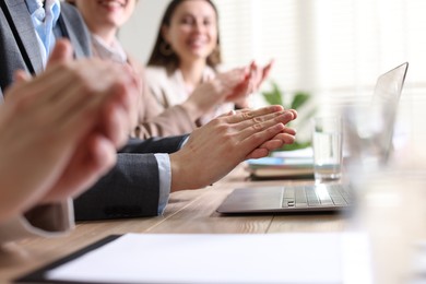 Photo of People applauding at table in office, closeup