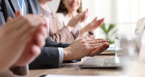 Photo of People applauding at table in office, closeup