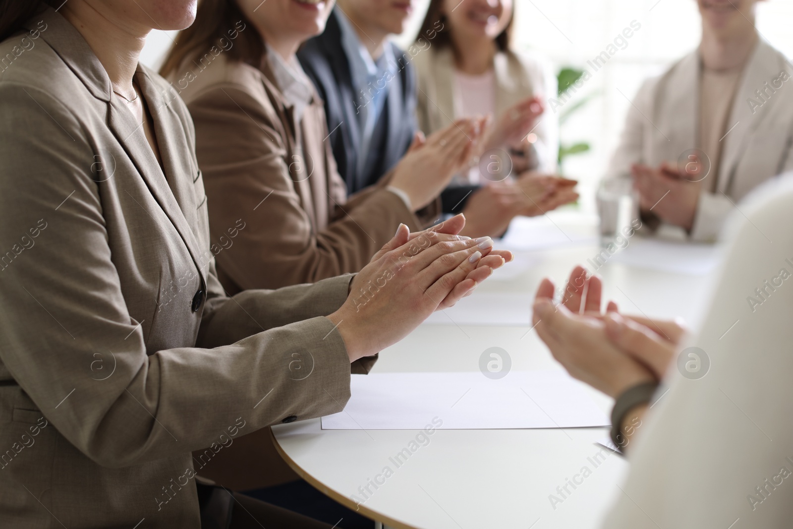 Photo of People applauding at table in office, closeup