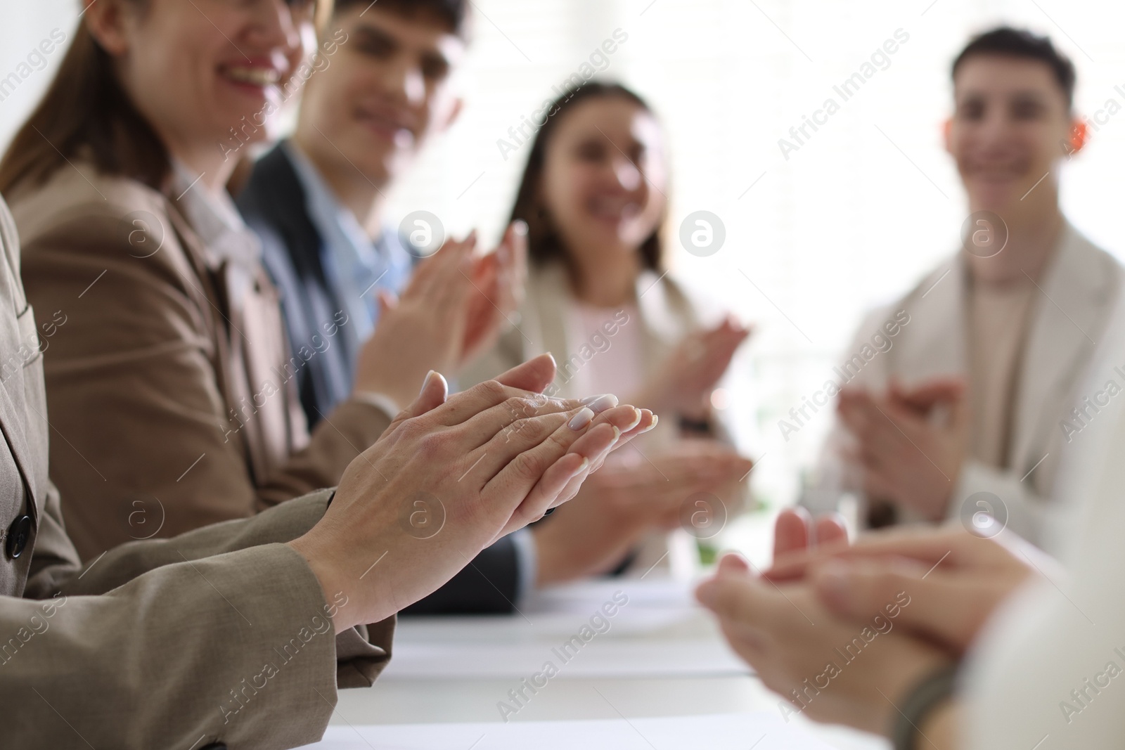 Photo of People applauding at table in office, closeup