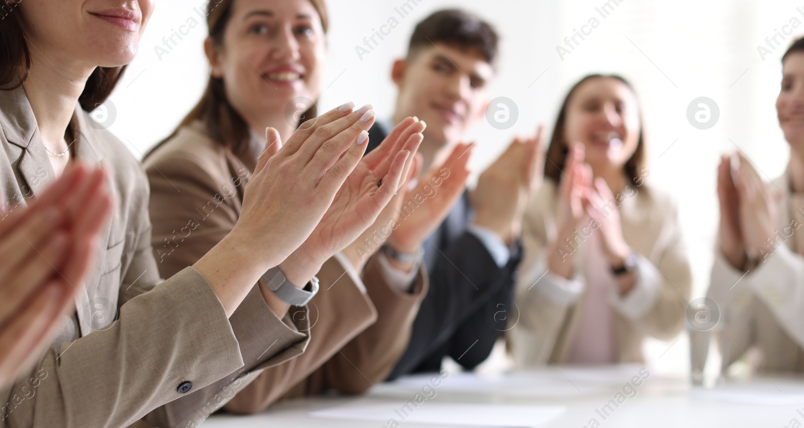 Photo of People applauding at table in office, closeup