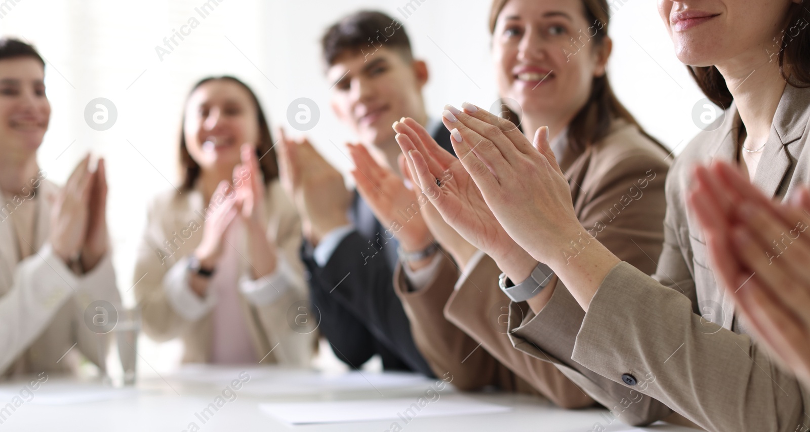 Photo of People applauding at table in office, closeup